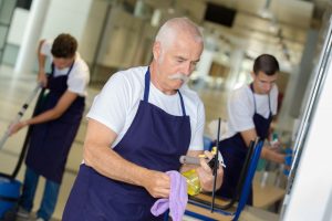 An older man holding a squeegee. commercial janitorial services