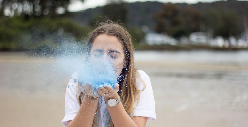 A woman blows blue dust from her hands. By knowing what airborne diseases can do, we can better treat them.